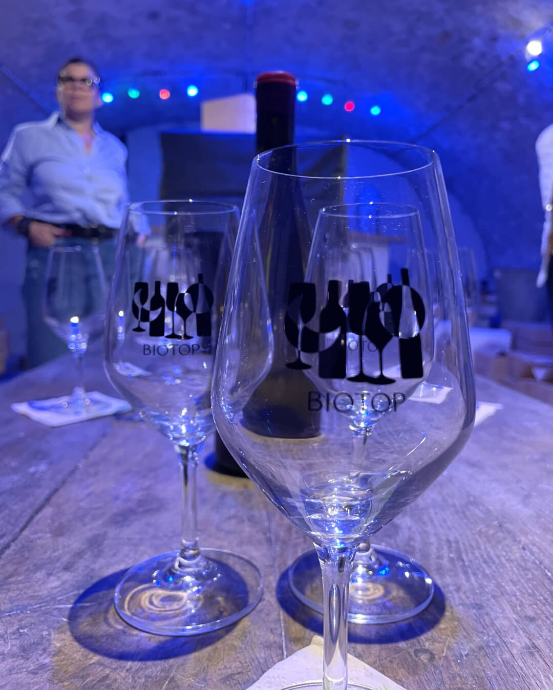 Vue d'une verre de vin devant le Wine Gaming installé dans la cave bleue de la vinothèque VUE sur Vignes à Sancerre, jeu ouvert à tous, pour les particuliers, les amis et les familles. Le meilleur escape game oenoludique de la région Centre-Val de Loire à Sancerre.