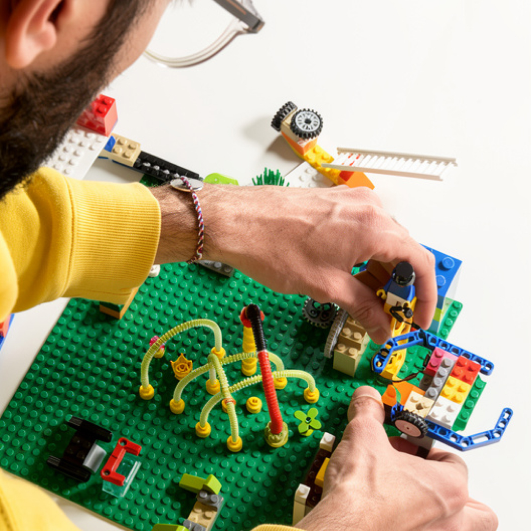 Un participant d'un ateliers LEGOⓇ SERIOUS PLAYⓇ construit un modèle de son entreprise avec des brises LEGOⓇ