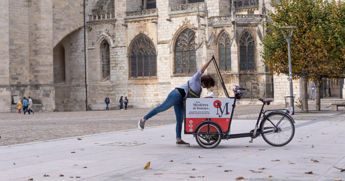 Photo Sophie avec le triporteur des Mystères de Bourges autour de la cathédrale Saint-Etienne de Bourges.